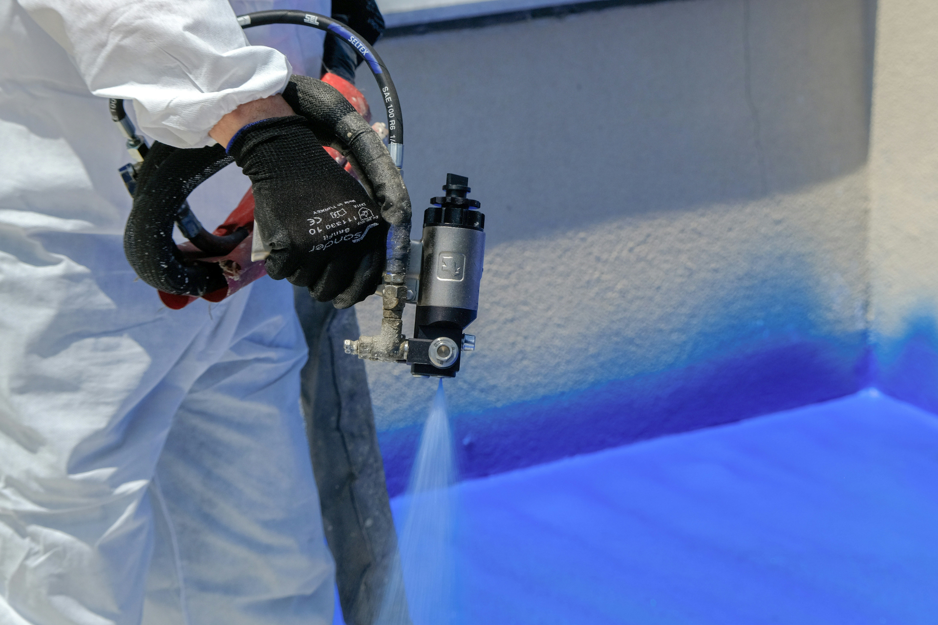 Contractor applying spray foam insulation to a wall